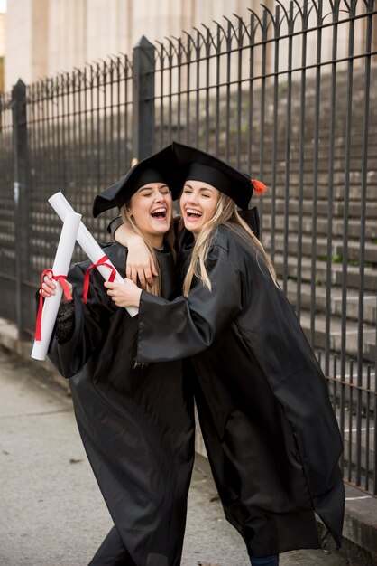 Colleghi di vista frontale che abbraccia alla laurea