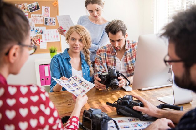 Colleghi in ufficio con macchine fotografiche e un computer