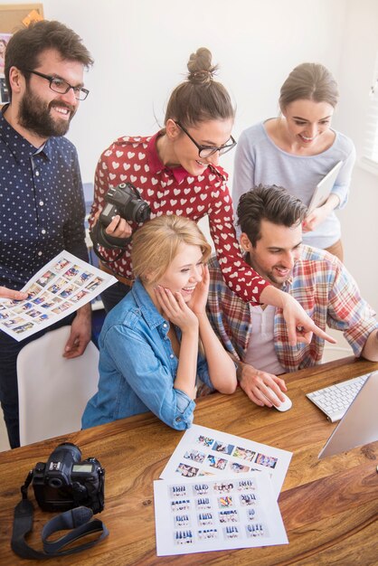 Colleghi in ufficio con macchine fotografiche e un computer