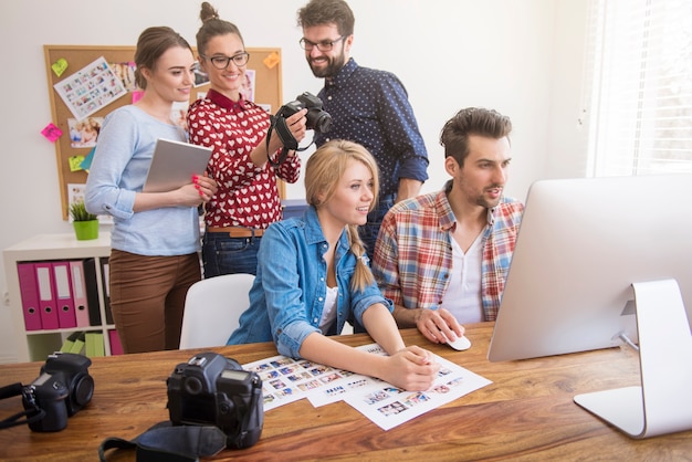 Colleghi in ufficio con macchine fotografiche e un computer