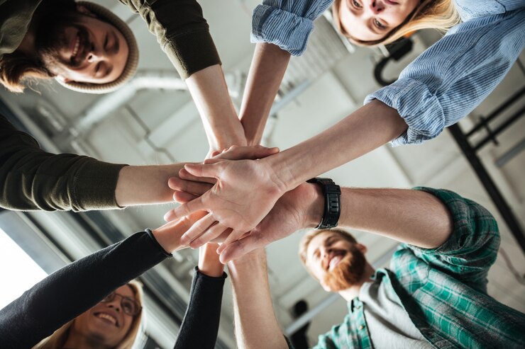 Foto gratuito colleghi in ufficio tenendosi per mano l'uno dall'altro