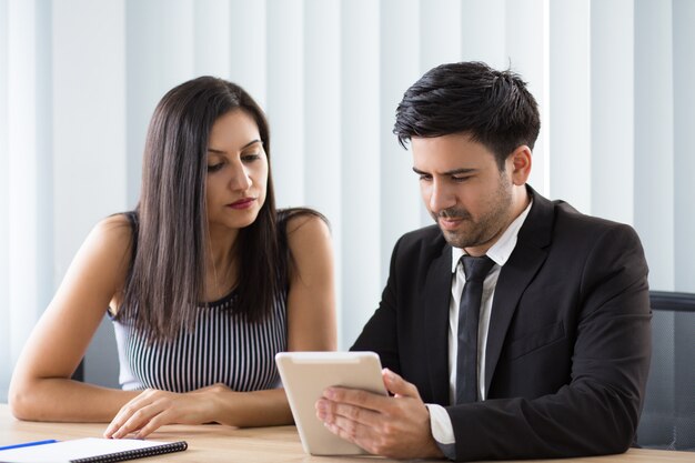 Colleghi multietnici concentrati che osservano il rapporto online