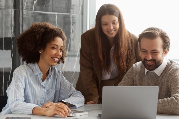 Colleghi sorridenti di tiro medio al lavoro