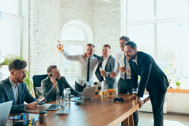 Colleghi spensierati felici che si divertono in ufficio mentre i loro colleghi lavorano sodo e altamente concentrati.