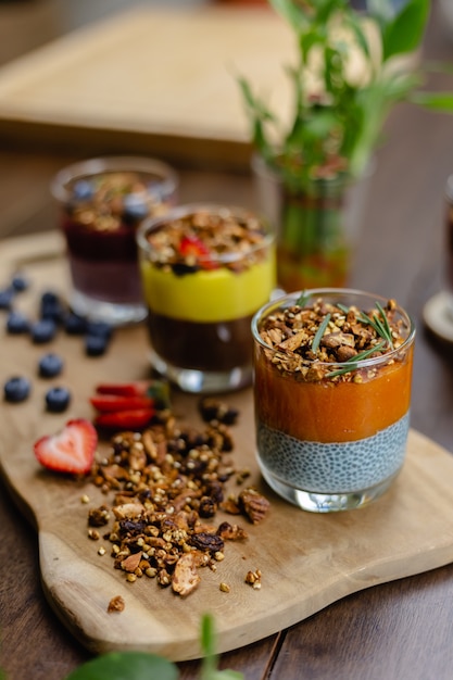 Colorata colazione sana dolce deserti alcuni budini di chia diversi in barattoli di vetro sul tavolo di legno in cucina a casa.