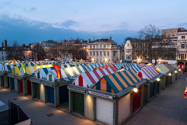 Colorato mercato di Norwich e il famoso castello al tramonto a Norfolk, Inghilterra, Regno Unito