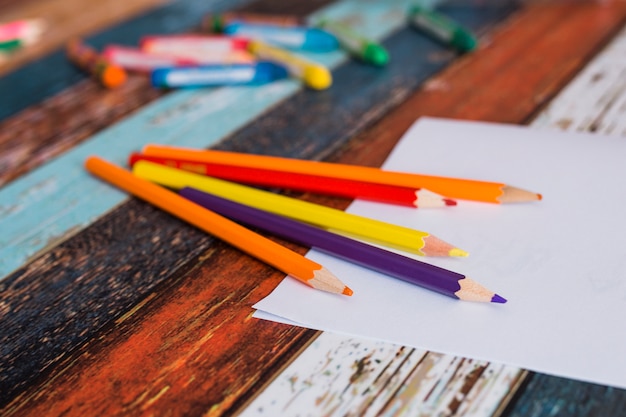 Colore della matita colorata e carta bianca sul vecchio tavolo dipinto