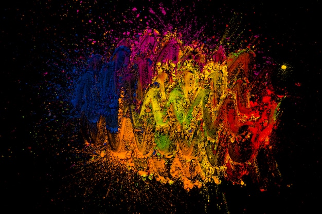 Colori brillanti di holi mescolati con il dito su uno sfondo nero