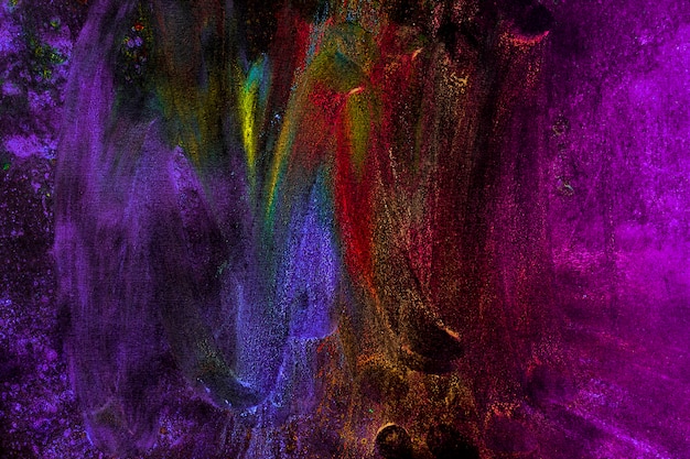 Colori multicolori di holi macchiati con la mano su fondo nero