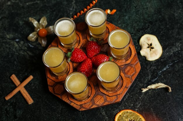 Colpi della frutta sulla vista superiore della fragola dell'arancia della cannella del bordo di legno