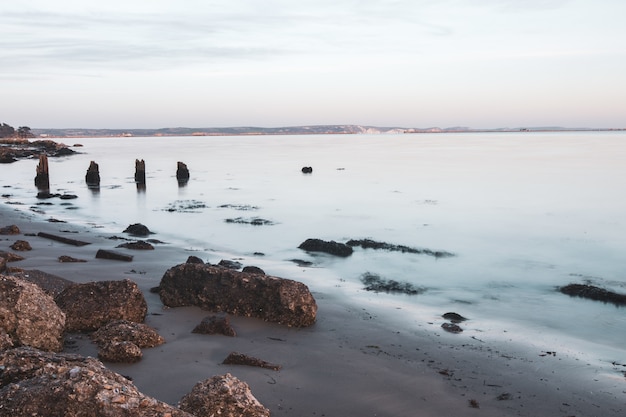 Colpo a lunga esposizione delle pietre sulla riva vicino a Portland, Weymouth, Dorset, Regno Unito