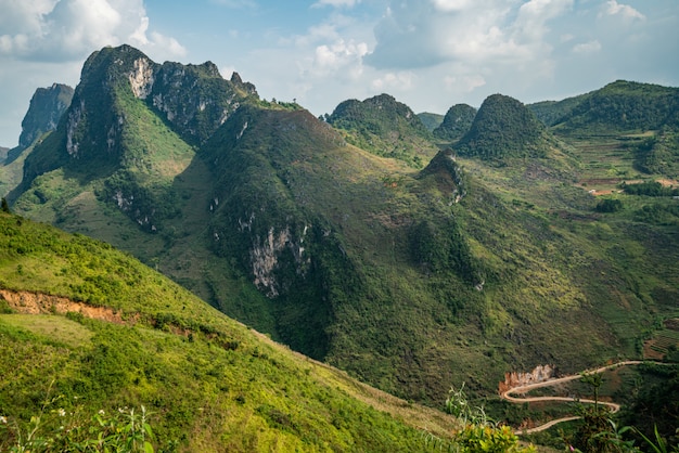 Colpo aereo di alte montagne verdi sotto il cielo nuvoloso nel Vietnam