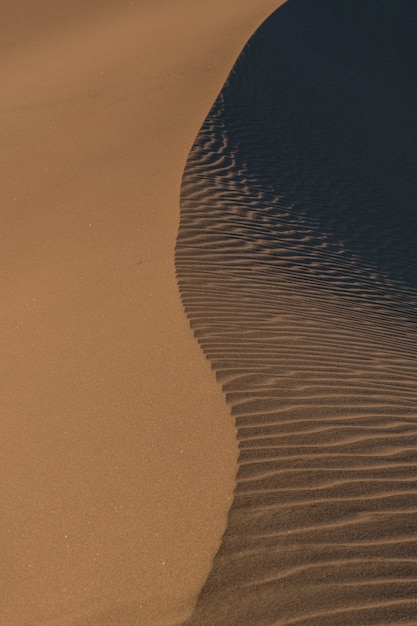 Colpo astratto verticale dell'acqua che raggiunge la sabbia della spiaggia lasciando tracce