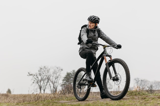 Colpo completo dell'uomo in sella a una bicicletta