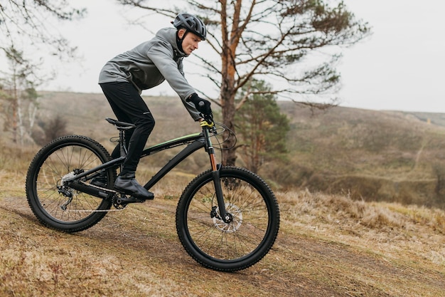 Colpo completo dell'uomo in sella a una bicicletta