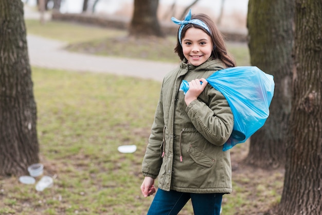 Colpo completo della bambina con il sacchetto di plastica