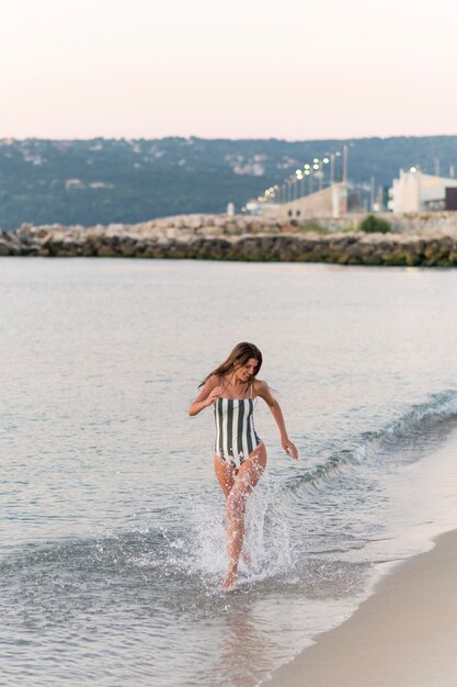 Colpo completo di bella ragazza in spiaggia