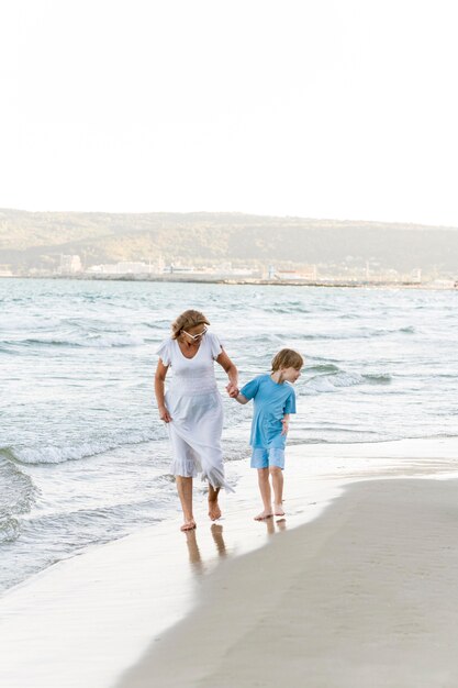 Colpo completo donna e bambino sulla spiaggia