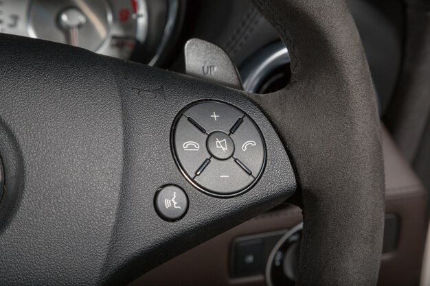 Colpo del primo piano dei pulsanti di chiamata sul volante di un'auto moderna