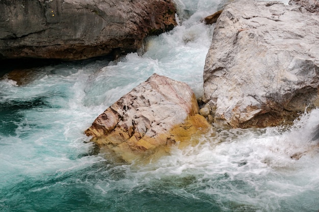 Colpo del primo piano dell'acqua che colpisce le rocce nel Parco Nazionale della Valle di Valbona in Albania