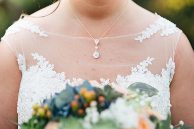 Colpo del primo piano della sposa in un abito da sposa che tiene il bouquet