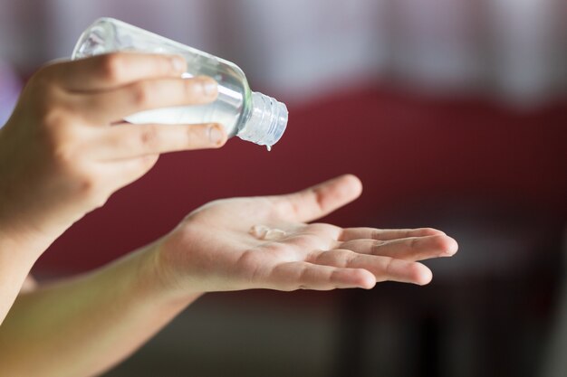 Colpo del primo piano delle mani utilizzando disinfettante per le mani