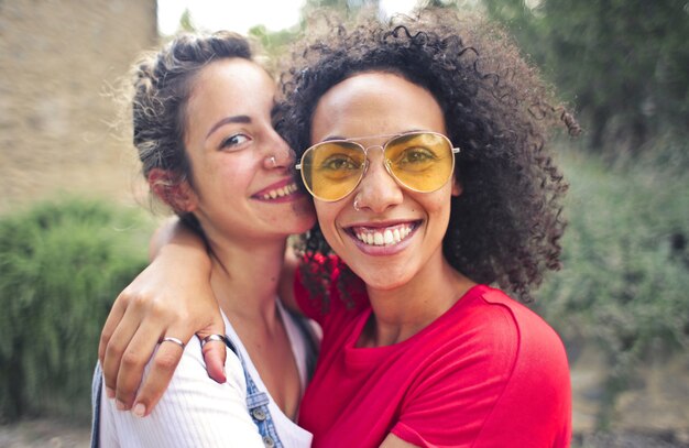 Colpo del primo piano di due amici sorridenti mentre si scattano foto all'aperto