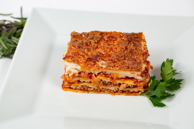 Colpo del primo piano di lasagne su un piatto bianco