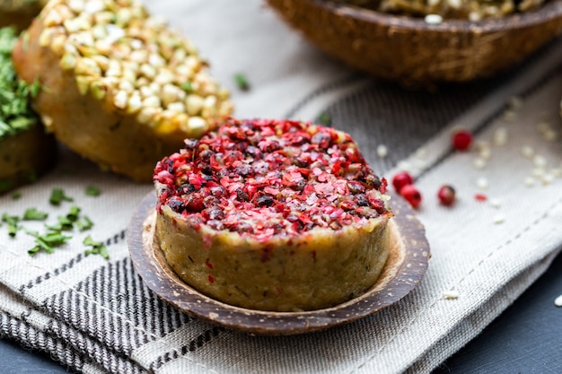 Colpo del primo piano di pane vegano crudo con pepe rosso