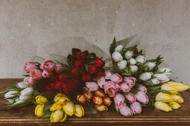 Colpo del primo piano di splendidi mazzi di tulipani colorati sul tavolo