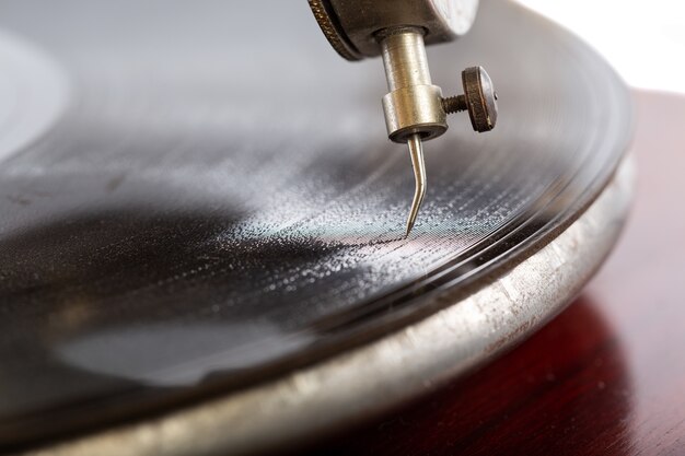Colpo del primo piano di un ago del grammofono con un disco di gommalacca