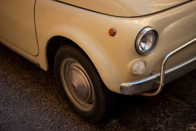 Colpo del primo piano di un'auto retrò bianca fredda parcheggiata sulla strada