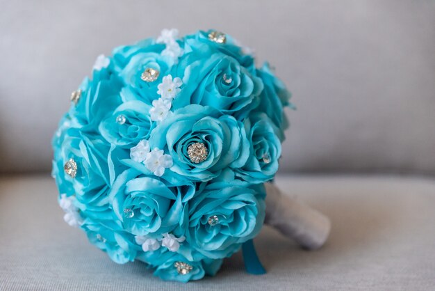 Colpo del primo piano di un bellissimo bouquet da sposa fatto di fiori blu e gioielli