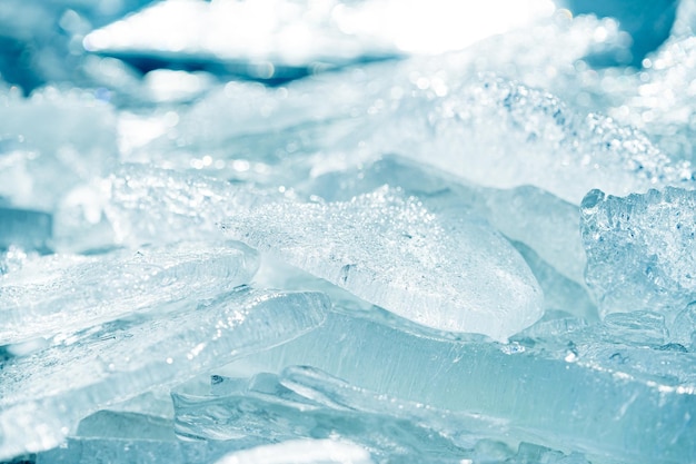 Colpo del primo piano di un ghiaccio trasparente brillante e limpido scintillante su una riva del lago selvaggia congelata