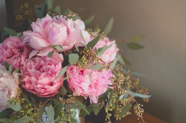 Colpo del primo piano di un mazzo di rose rosa e altri fiori con foglie verdi