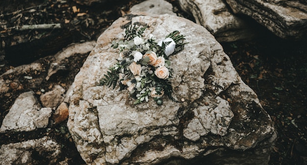 Colpo del primo piano di un mazzo di rose su una roccia