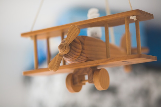 Colpo del primo piano di un vecchio aeroplano in miniatura di legno con uno sfondo sfocato