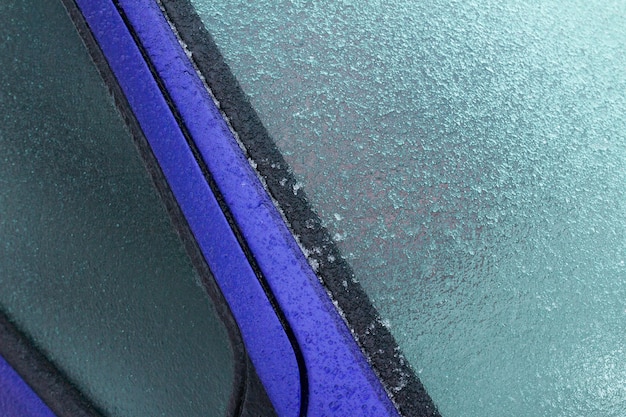 Colpo del primo piano di una brina nell'auto blu durante l'inverno