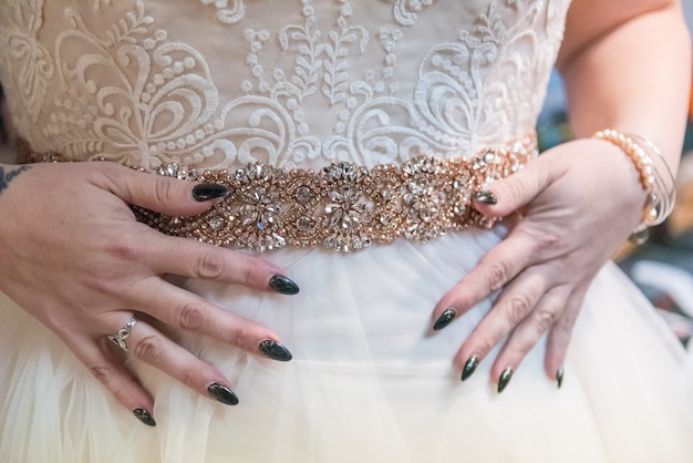 Colpo del primo piano di una donna che prova su un bellissimo abito da sposa fatto a mano