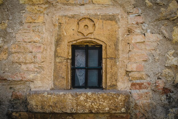 Colpo del primo piano di una finestra chiusa su una parete di pietra gialla