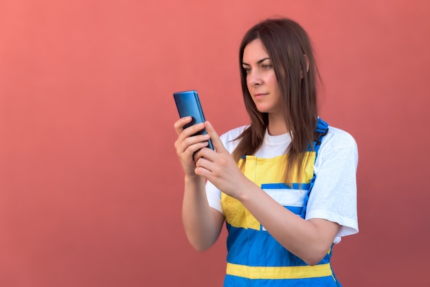 Colpo del primo piano di una giovane donna con il suo smartphone in posa