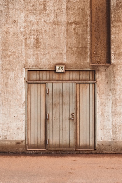 Colpo del primo piano di una porta di legno marrone di un edificio in cemento