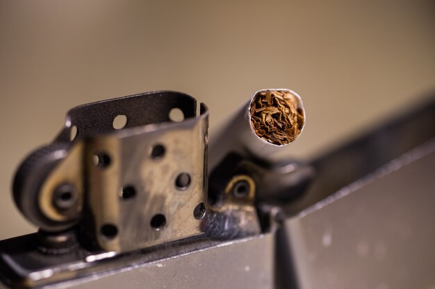 Colpo del primo piano di una sigaretta in un accendino zippo