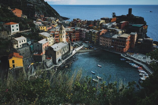 Colpo dell'angolo alto dello stagno con le barche vicino all'edificio a Vernazza