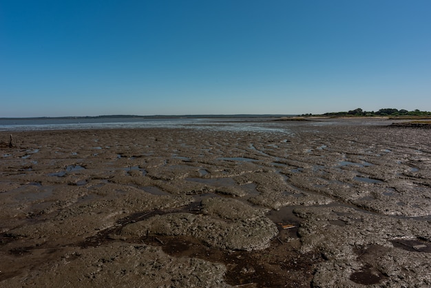 Colpo della spiaggia di sabbia asciutta a Cais Palafítico da Carrasqueira, Portogallo durante la bassa marea