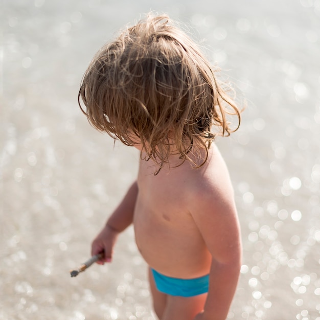 Colpo di alto angolo del bambino in piedi sulla spiaggia