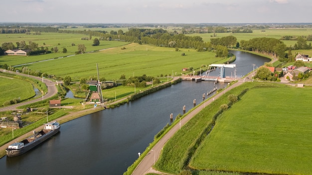 Colpo di alto angolo del canale Merwede circondato da campi erbosi catturati in Nehterlands