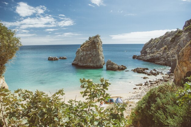 Colpo di alto angolo di molte formazioni rocciose vicino al mare sulla spiaggia durante il giorno