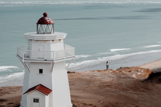 Colpo di alto angolo di un bellissimo faro sulla spiaggia con vista sull'oceano