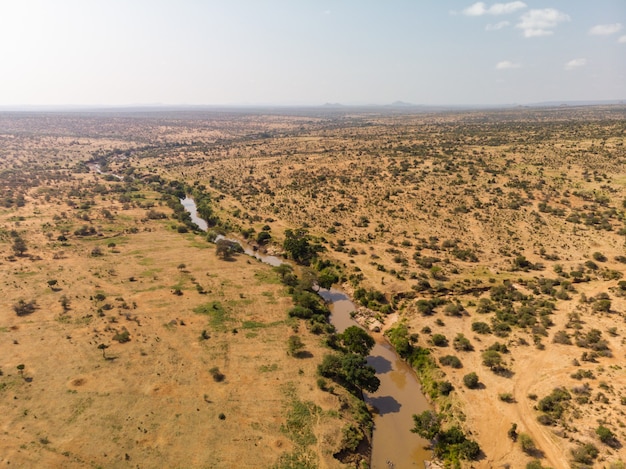 Colpo di alto angolo di un fiume fangoso che attraversa il deserto catturato a Samburu, in Kenya